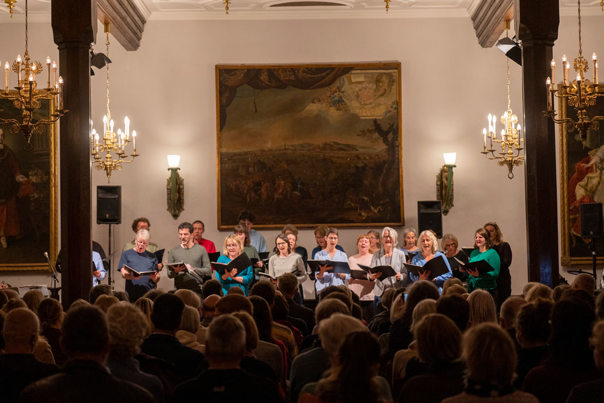 Mehrere Personen singen vor einem Publikum