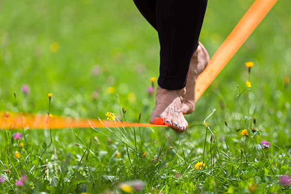 Person balanciert auf einem Slackline Band