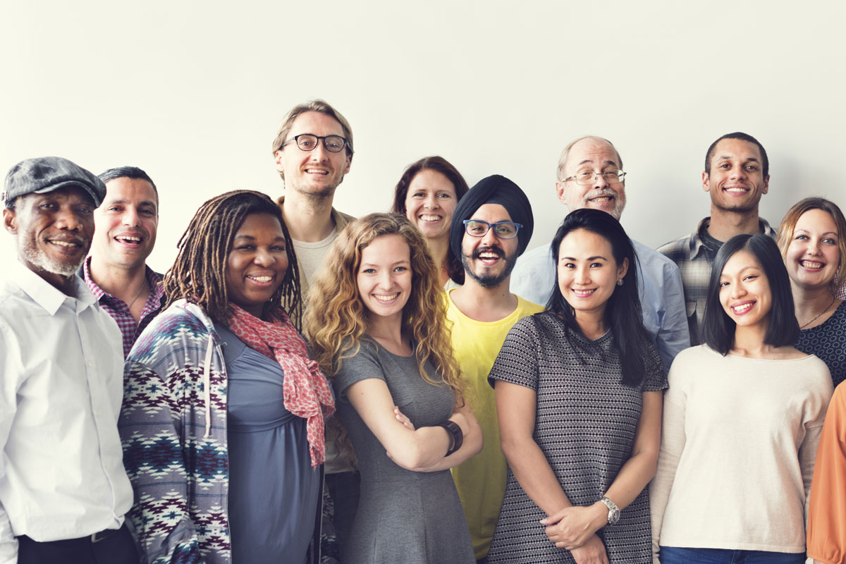 Eine Gruppe diverser Personen posiert für ein Foto. 