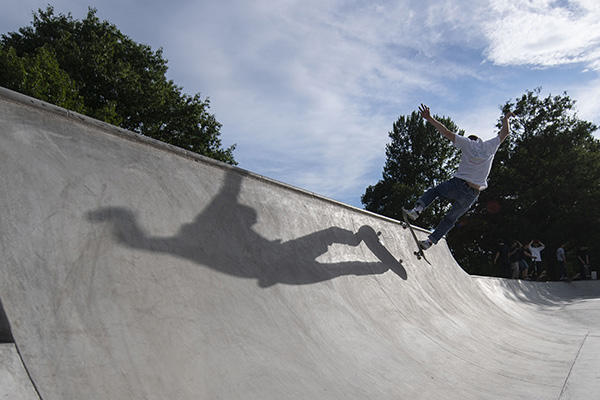 Person mit Skateboard auf Halfpipe