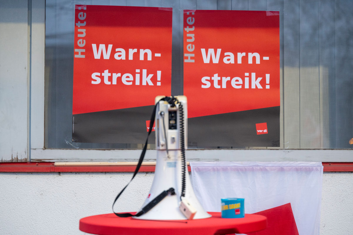Plakate "Heute - Warnstreik!", im Vordergrund ein Megafon