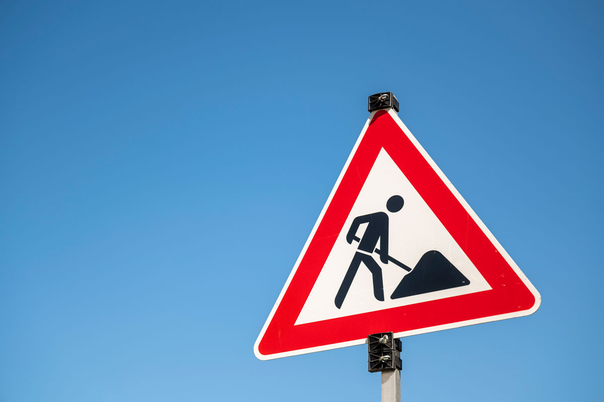 Schild mit einer Person, die eine Schaufel hält; Baustellenschild