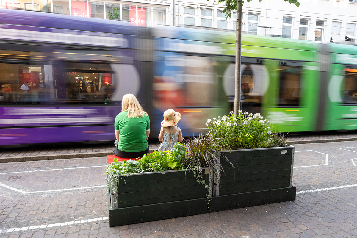 Erwachsene und Kind auf einer Bank in der Innenstadt